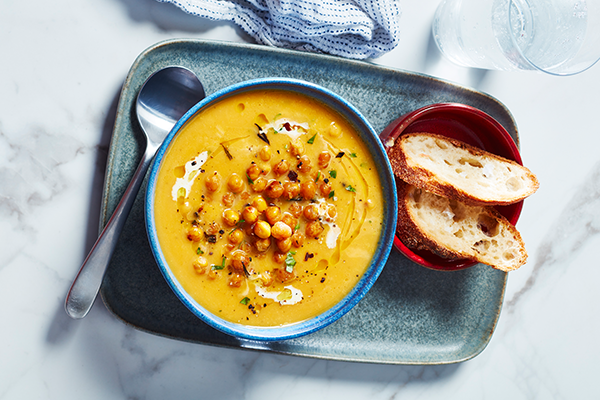 Bowl of creamy yellow soup topped with crispy roasted chickpeas