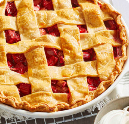 strawberry rhubarb pie with a lattice design on a stipped white napkin with a pie server
