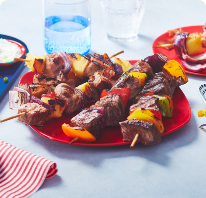 Three types of grilled kabobs on assorted plates
