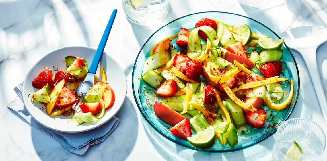 Blue serving dish and side bowl of strawberry, mango, and peach summer salad